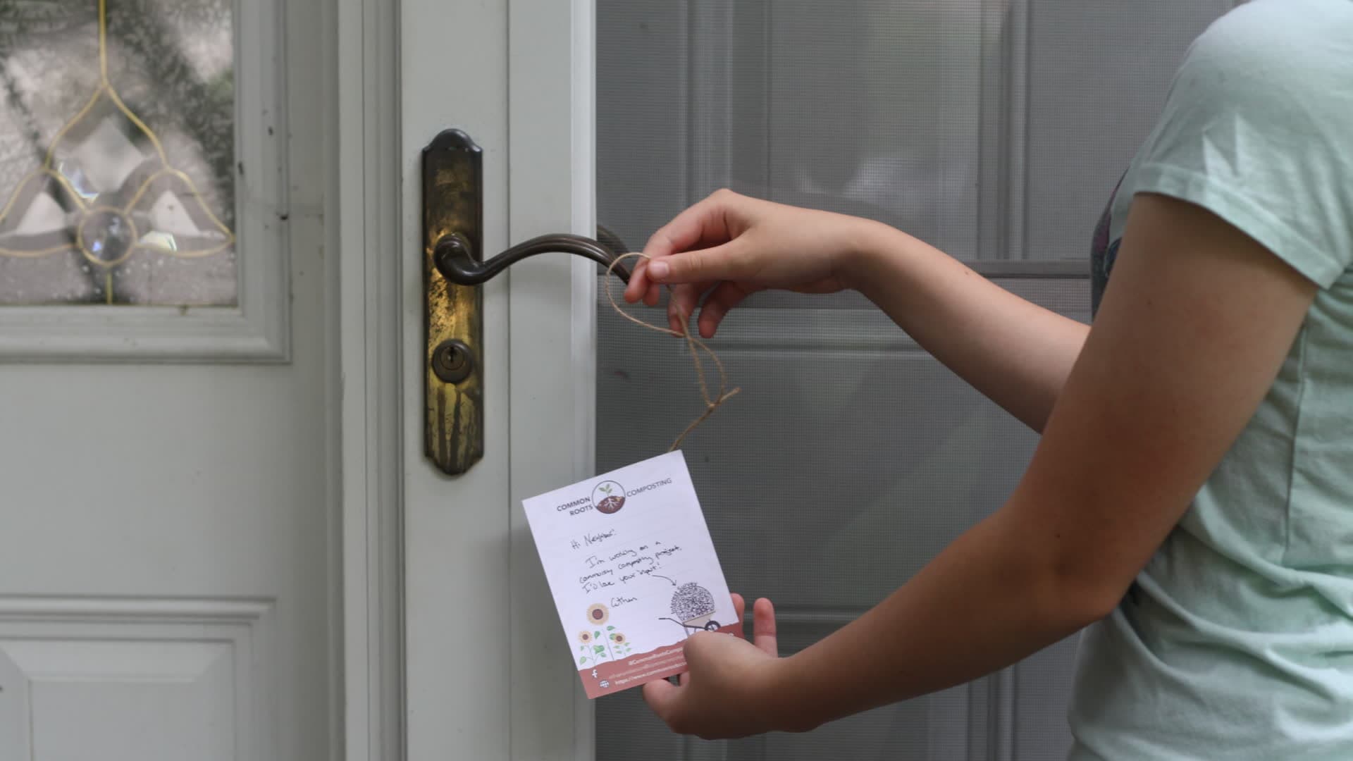 A neighbor placing a Kingfisher Composting door-hanger flyer on a front door